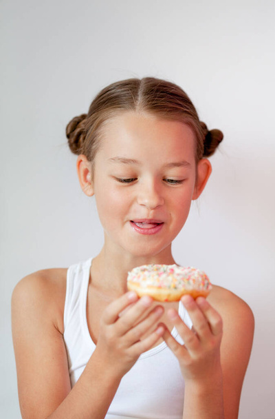 chica sosteniendo un apetitoso donut glaseado en sus manos - Foto, Imagen