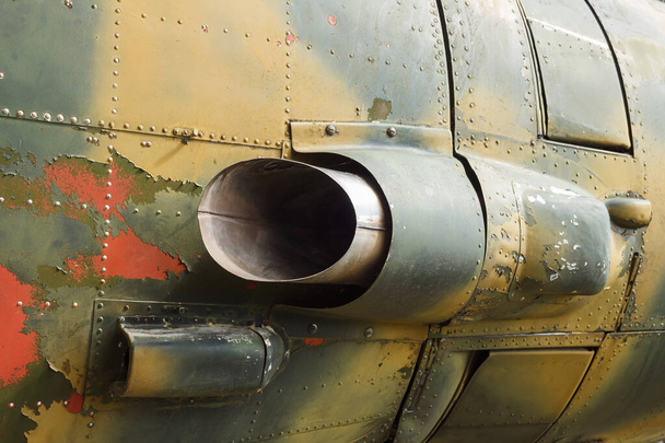 Details over de romp van een oud vliegtuig. Oud camouflage oppervlak met geexfolieerde verf en klinknagels op een militair vliegtuig. - Foto, afbeelding
