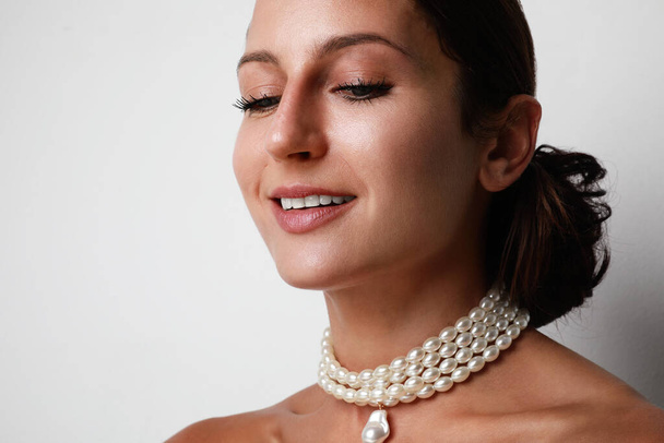 Portrait of a bride with pearl necklace and nude make-up, young brunette, tender photo wedding portrait. - Foto, afbeelding