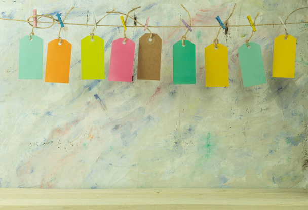 Labels in different colors as a background. Rope tags as background. The labels are suspended by a rope on multi-colored clothespins - Photo, Image