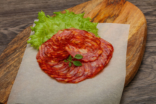 İtalyan geleneksel Chorizo domuz sosisleri fesleğen yaprağı servis ediyordu. - Fotoğraf, Görsel