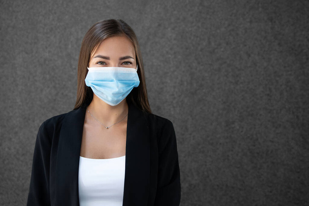 Retrato de una joven empresaria con una máscara médica protectora en la cara. Copiar espacio - Foto, imagen