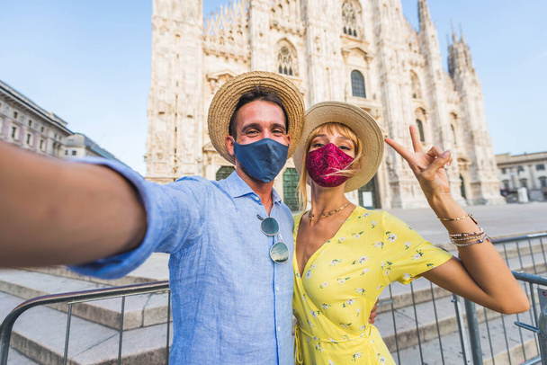 Beautiful couple of lovers sightseeing in Italy - Playful tourists visiting the Duomo cathedral in Milan - Photo, Image