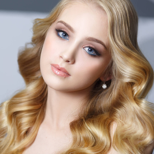 Beauty portrait of a beautiful blonde girl with flowing curls. - Zdjęcie, obraz