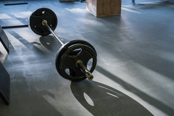 Barbell on the floor in the gym - Фото, зображення
