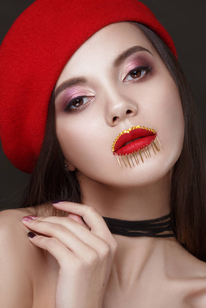 Beautiful brunette with creative aggressive makeup makeup with a dark background. - 写真・画像