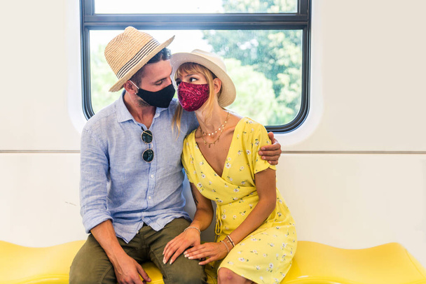 Beautiful couple driving on a subway wagon during covid-19 pandemic, concepts about lifestyle, trasportation and social distancing - Foto, Imagem