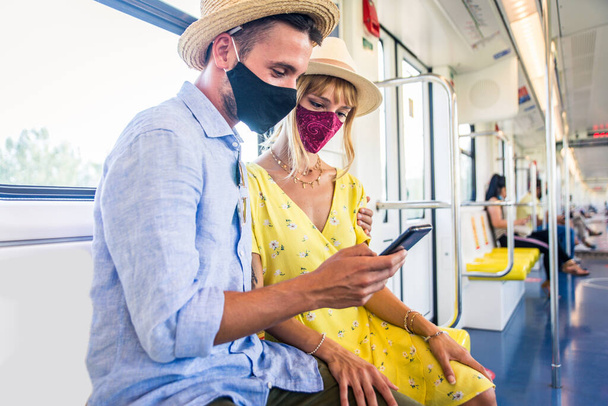 Beautiful couple driving on a subway wagon during covid-19 pandemic, concepts about lifestyle, trasportation and social distancing - Fotoğraf, Görsel
