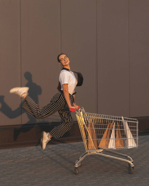 Joyful girl with shopping outside a shopping mall  - Фото, зображення