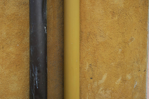 yellow ochre plastered wall with drainpipes, brown and yellow - Photo, Image