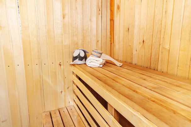 Szczegóły wnętrza sauna fińska łaźnia parowa z tradycyjnymi akcesoriami do sauny czerpak filcowy ręcznik kapelusz. Tradycyjna, stara rosyjska łaźnia SPA Concept. Relaks kraju wieś kąpiel koncepcja - Zdjęcie, obraz