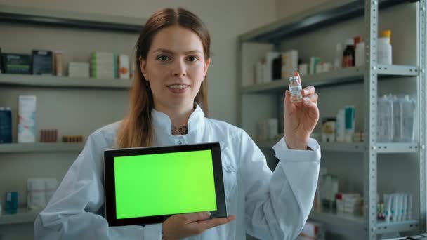 Donna con fiala e compressa con schermo verde in farmacia. - Filmati, video