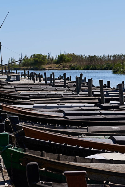 Set von kleinen Booten in einem Fischereihafen. See, blauer Himmel, Schilf, Holz - Foto, Bild
