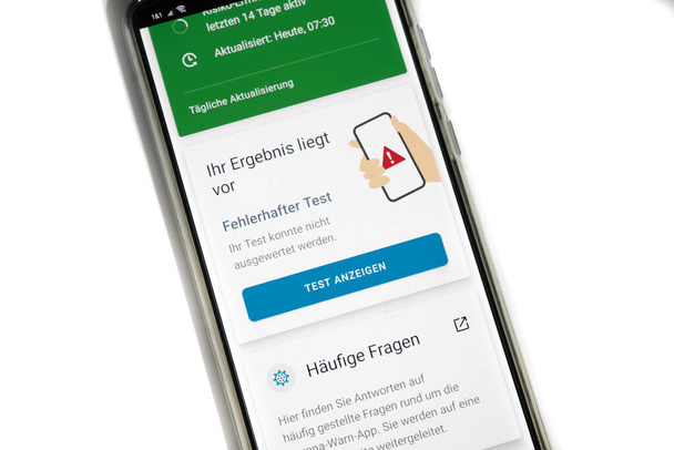スマートフォン上のコロナ警告アプリがテスト結果を表示-間違って-画像上のドイツ語の単語 - 写真・画像