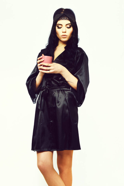 sexy chica posando en negro túnica de seda con taza - Foto, imagen