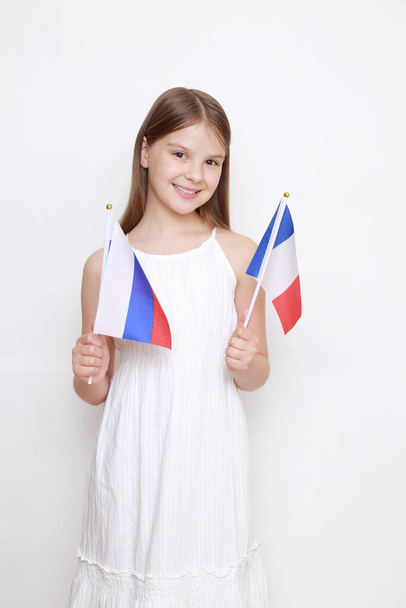 Little girl holding flags of Russian Federation and France. - Foto, immagini