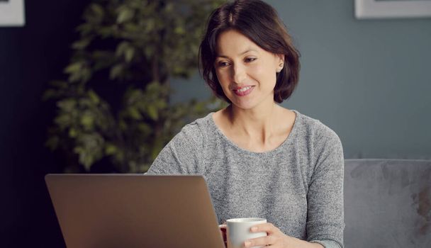 Lächelnde Frau schaut auf Laptop-Bildschirm - Foto, Bild