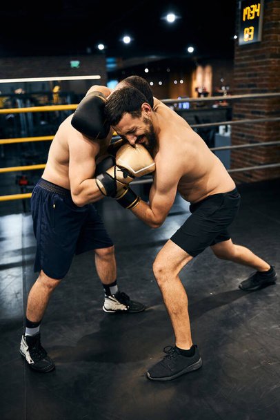 Zwei Boxer halten sich fest und schlagen aufeinander ein - Foto, Bild