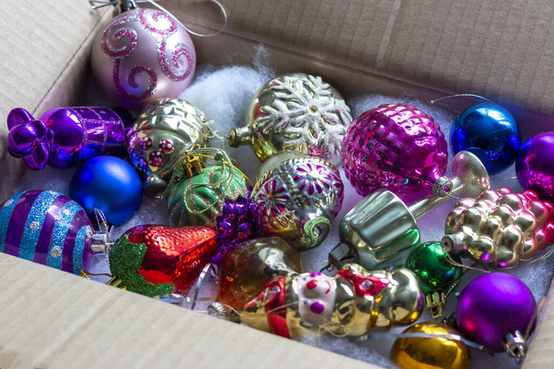 Eine Schachtel mit altem sowjetischem Glas-Weihnachtsspielzeug wird in Vorfreude auf das Fest ausgepackt. - Foto, Bild
