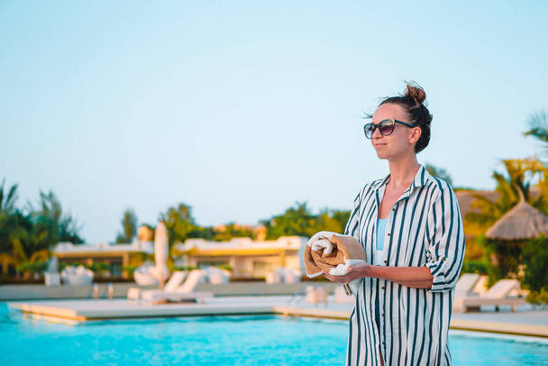 Jovem mulher bonita desfrutando de férias de verão na piscina de luxo - Foto, Imagem