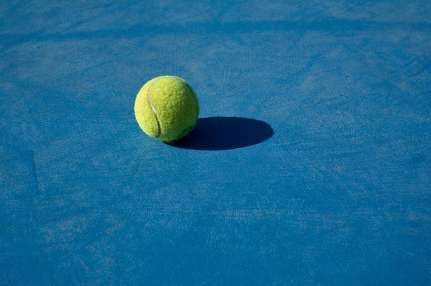 detail žlutého tenisového míčku na modrém kurtu - Fotografie, Obrázek