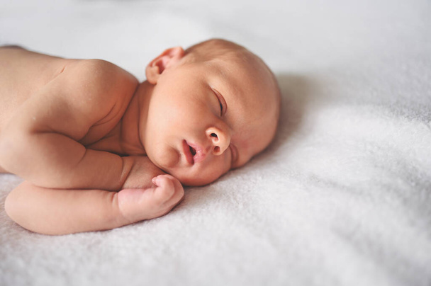 Χαριτωμένο συναισθηματικό νεογέννητο αστείο αγοράκι που κοιμάται στην κούνια. Πρότυπο συσκευασίας ειδών μωρών. Υγιές παιδί, έννοια του νοσοκομείου και ευτυχισμένη μητρότητα. Βρέφος. Φυτώριο - Φωτογραφία, εικόνα