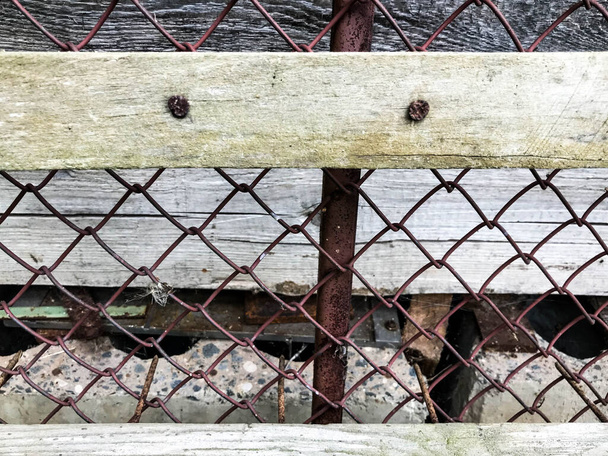 texture, metal mesh. on the net there are wooden sticks nailed down. homemade dog booth. fencing, pet protection. dog house, small pet room - Photo, Image
