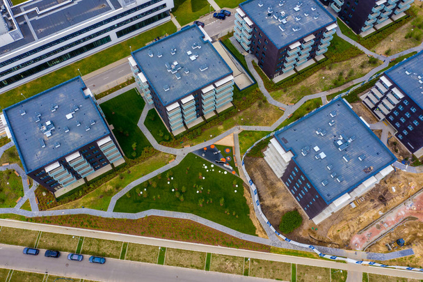 Vista aérea de casas residenciais e calçadas bairro. Casas apertadas, rodeado por árvores verdes sobrevoam a Europa. Desenvolvimento da comunidade habitacional suburbana - Foto, Imagem