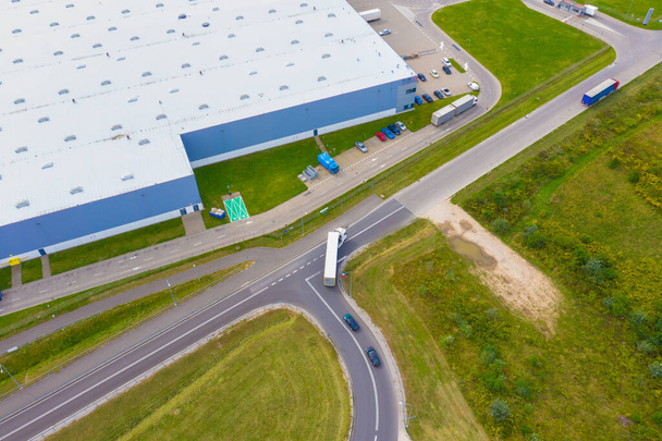 Dağıtım merkezinin hava görüntüsü, endüstriyel lojistik bölgenin insansız hava aracı fotoğrafları. Lojistik merkezine giden kamyonlar - Fotoğraf, Görsel