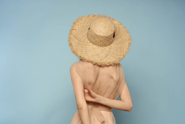 Γυναίκα σε καπέλο με γυμνή πλάτη σε μπλε φόντο μοντέλο πίσω όψη - Φωτογραφία, εικόνα