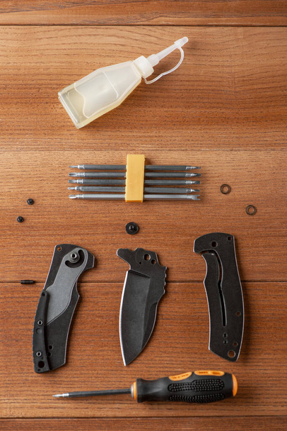 Screwdriver set, disassembled pocket knife and a bottle of household oil - Фото, изображение