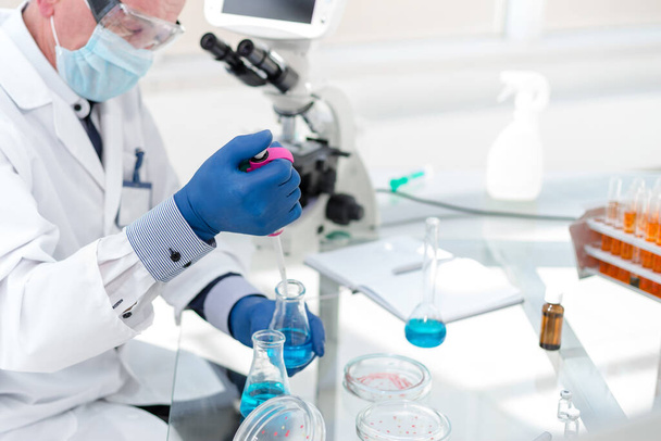 employees of the scientific laboratory examining the liquid in a laboratory flask . - Foto, immagini