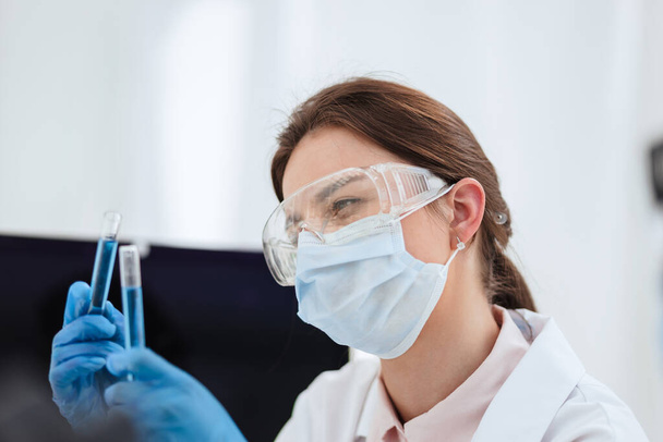 close up. female scientist looking at liquid in test tubes. - Φωτογραφία, εικόνα