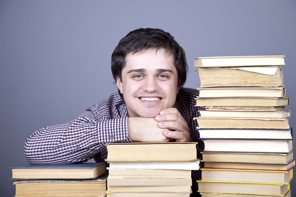 ο νεαρός φοιτητής χαμογελώντας με τα βιβλία που απομονώνονται. - Φωτογραφία, εικόνα