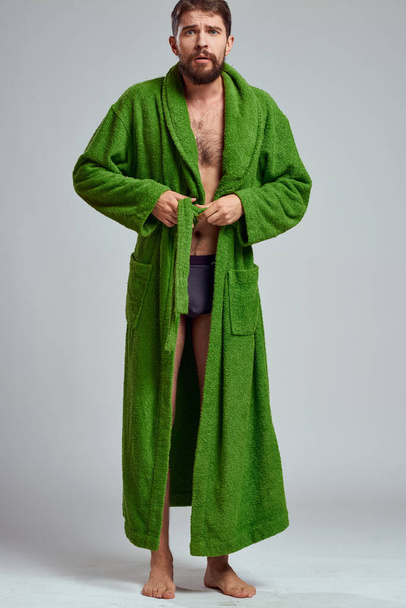 emotionaalinen mies vihreässä kaapussa kevyellä taustalla täydessä kasvussa hauskaa tunteita malli - Valokuva, kuva