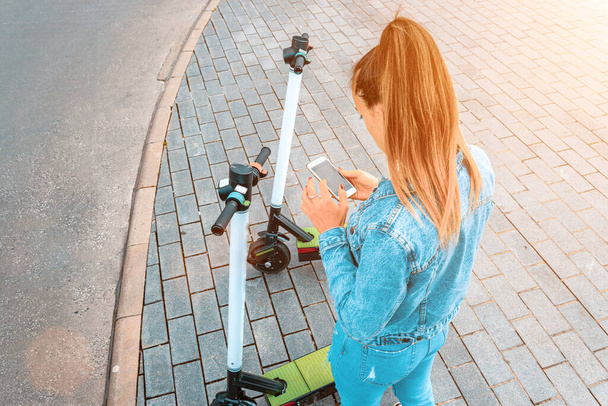 Transporte eléctrico: patada scooter eléctrico de la ciudad usando de chica. Estilo de vida urbano. Concepto de transporte urbano eléctrico - Foto, Imagen