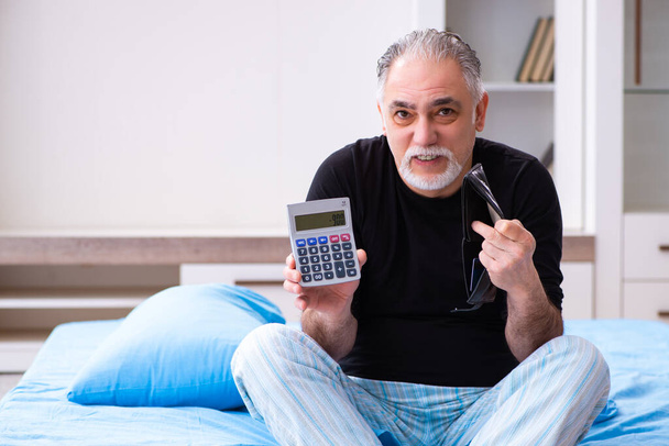 Old man in bankruptcy concept in the bedroom - Foto, Bild