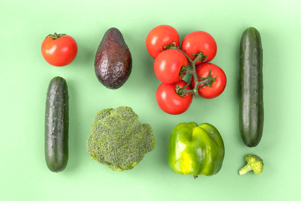 Mise en page créative faite de poivre, avocat, concombre, brocoli et tomate. Couché plat, vue du dessus. - Photo, image