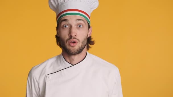 Portret profesjonalnego, podnieconego włoskiego kucharza w mundurze zaskakująco wyglądającego w aparacie pokazującego odizolowany gest kciuka w górę. Przestrzeń kopiowania - Materiał filmowy, wideo