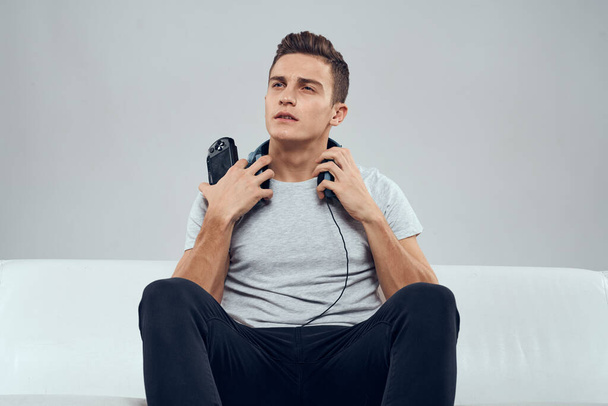 Чоловік сидить на дивані навушники джойстик ігри розважальна залежність технологія дозвілля
 - Фото, зображення