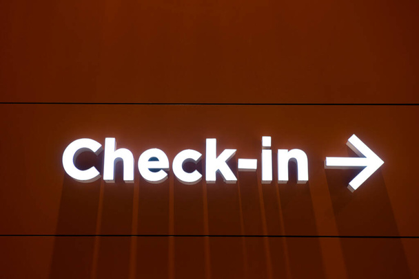 Lotnisko check-in oświetlony znak ze strzałką w prawo w ścianie. - Zdjęcie, obraz