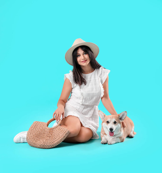 Femme avec chien corgi mignon sur fond de couleur - Photo, image