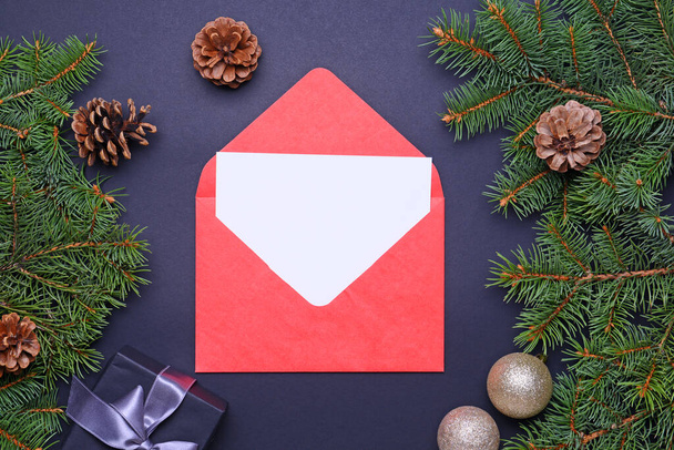 Koyu arkaplanda boş kart ve zarf olan güzel Noel süsleri - Fotoğraf, Görsel