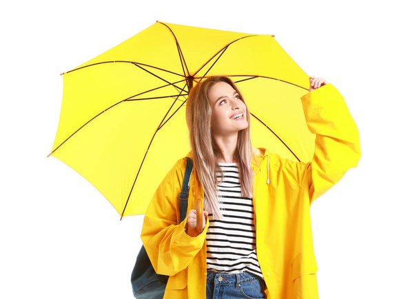 Schöne junge Frau in Regenmantel und mit Regenschirm auf weißem Hintergrund - Foto, Bild