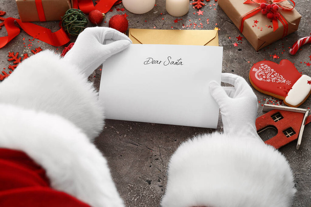 Santa Claus reading letter at table - Фото, зображення