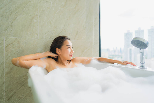Portrét krásná mladá asijská žena relaxovat a volný čas ve vaně dekorace v koupelně interiéru - Fotografie, Obrázek