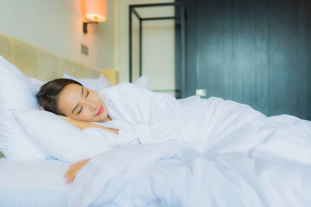 Portrait beautiful young asian woman sleep on bed with pillow and blanket in bedroom interior - Photo, Image