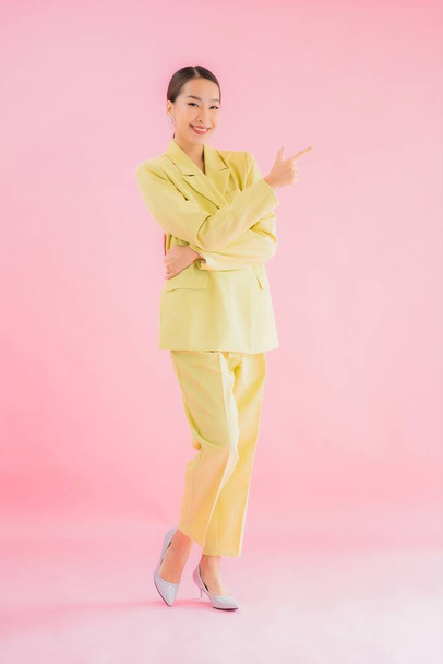 Portrait belle jeune femme d'affaires asiatique sourire en action sur fond de couleur rose - Photo, image