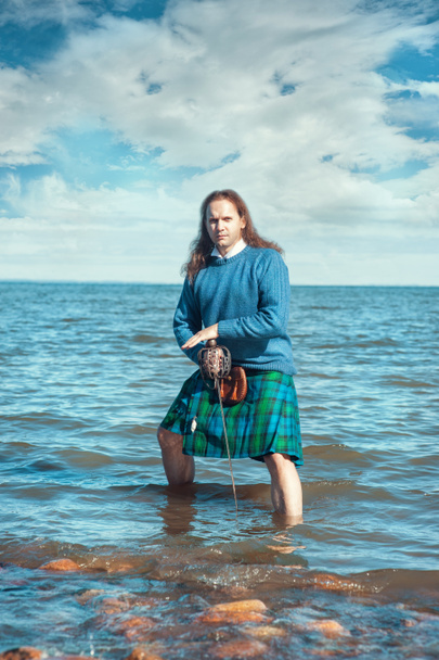 Homem corajoso com espada em traje escocês
 - Foto, Imagem