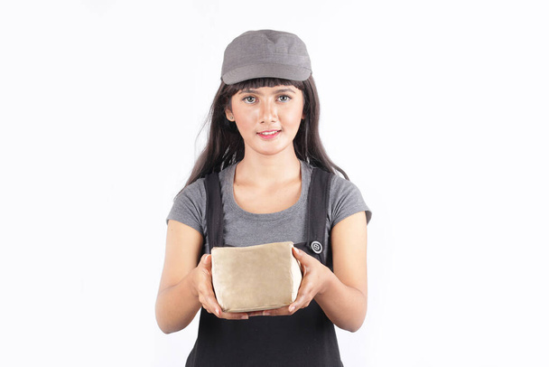 post woman take package isolated. transportation, post and people concept smiling young woman holding cardboard box - Photo, Image